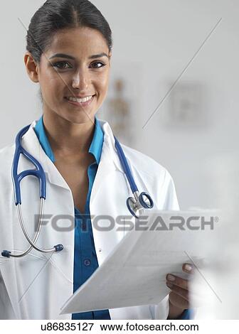 Doctor reading a patient's notes View Large Photo Image Stock Photo - Doctor reading a patient's notes. Fotosearch