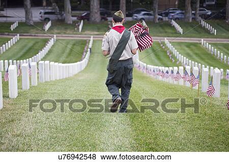 Stock Photo - "Boyscout places one of 85, 000 US Flags at 2014 Memorial Day Event, Los Angeles National Cemetery, California, USA". Fotosearch