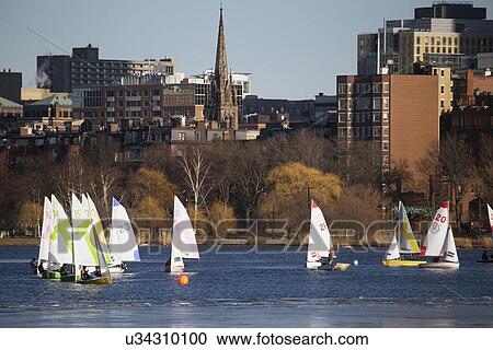 Stock Image - "Colorful docked sailboats and Boston Skyline in winter on half frozen Charles River, Massachusetts, USA". Fotosearch