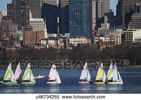 Stock Photography - "Colorful docked sailboats and Boston Skyline in winter on half frozen Charles River, Massachusetts, USA". Fotosearch