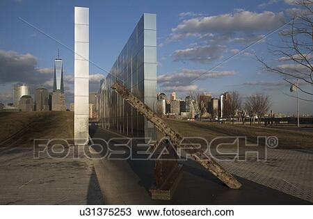 Stock Image - "Empty Sky: Jersey City 9/11 Memorial at sunset shows iron beam from W. T. C., New Jersey, USA". Fotosearch