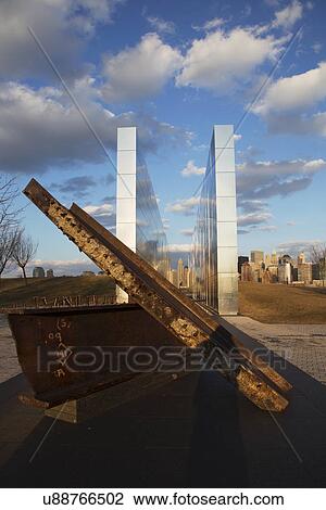 Stock Image - "Empty Sky: Jersey City 9/11 Memorial at sunset shows iron beam from W. T. C., New Jersey, USA". Fotosearch