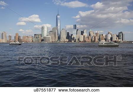 "From New Jersey, a water taxi is seen in front of New York City Skyline featuring One World Trade Center (1WTC), Freedom Tower, New York City, New York, USA" View Large Photo Image Stock Photo - "From New Jersey, a water taxi is seen in front of New York City Skyline featuring One World Trade Center (1WTC), Freedom Tower, New York City, New York, USA". Fotosearch