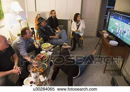 Stock Photography - "Group of people watch NFL Superbowl XLVIII on television, Feb. 2, 2014, Denver Broncos vs. Seattle Seahwaks". Fotosearch