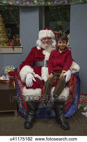 Stock Image - "Little boy sits on Santa's lap at Christmas dinner for US Soldiers at Wounded Warrior Center, Camp Pendleton, North of San Diego, California, USA". Fotosearch