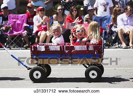 "Little girls wave in little red wagon, July 4, Independence Day Parade, Telluride, Colorado, USA" View Large Photo Image Stock Image - "Little girls wave in little red wagon, July 4, Independence Day Parade, Telluride, Colorado, USA". Fotosearch