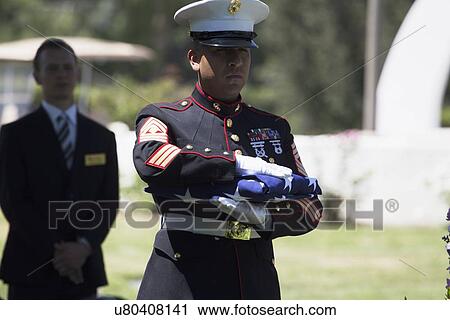 Stock Image - "Marine folds flag at Memorial Service for fallen US Soldier, PFC Zach Suarez, ""Honor Mission"" on Highway 23, drive to Memorial Service, Westlake Village, California, USA". Fotosearch