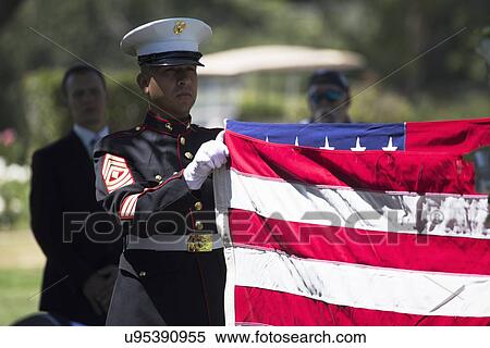 Stock Photography - "Marine folds flag at Memorial Service for fallen US Soldier, PFC Zach Suarez, ""Honor Mission"" on Highway 23, drive to Memorial Service, Westlake Village, California, USA". Fotosearch
