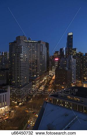 Stock Image - "New York City skyline at dusk looking south down Broadway from Lincoln Center, New York City, New York, USA". Fotosearch