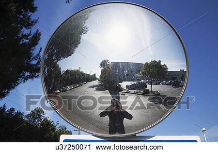 Stock Image - "Photographer in concave mirror photographs himself, Ventura, California, USA". Fotosearch