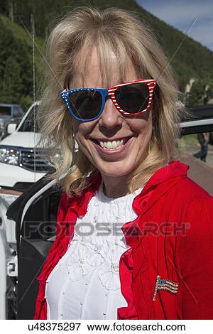 Stock Photo - "Pretty blond woman in red white and blue colors smiles, July 4, Independence Day Parade, Telluride, Colorado, USA". Fotosearch