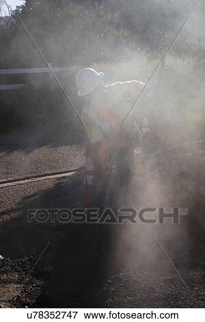 "Roadworker repaves road with steam, Encino Drive, Oak View, California, USA" View Large Photo Image Stock Photo - "Roadworker repaves road with steam, Encino Drive, Oak View, California, USA". Fotosearch