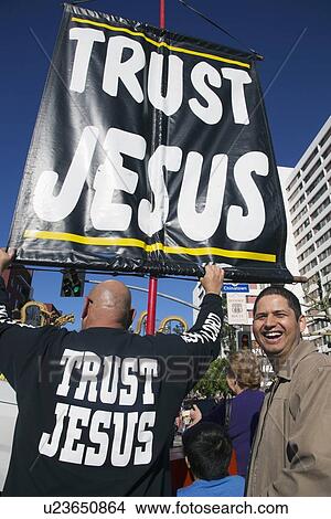 Picture - "Sign reads ""Trust Jesus"" sign and man mocking him, Chinese New Year, Los Angeles, California, USA". Fotosearch