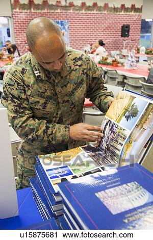 Stock Image - "Soldier looks at Visions of America book at Christmas dinner, Wounded Warrior Center, Camp Pendleton, North of San Diego, California, USA". Fotosearch