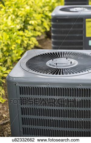 Stock Image - Air conditioning unit in garden. Fotosearch