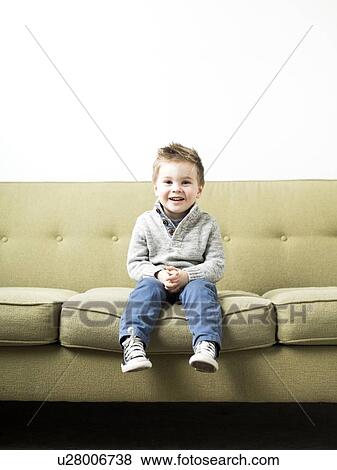 Baby boy (2-3) sitting on sofa View Large Photo Image Stock Photo - Baby boy (2-3) sitting on sofa. Fotosearch