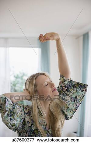 Stock Photo - Blond woman stretching at home. Fotosearch