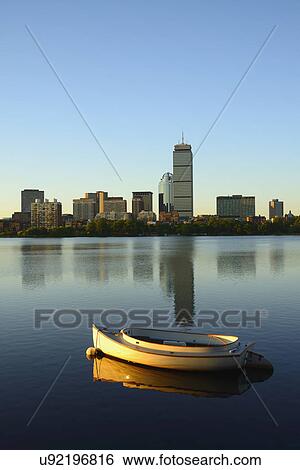 Stock Photograph - Boat on river with skyline in background. Fotosearch