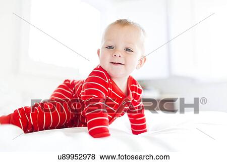Boy (2-3) in striped pajamas crawling on bed View Large Photo Image Stock Photo - Boy (2-3) in striped pajamas crawling on bed. Fotosearch