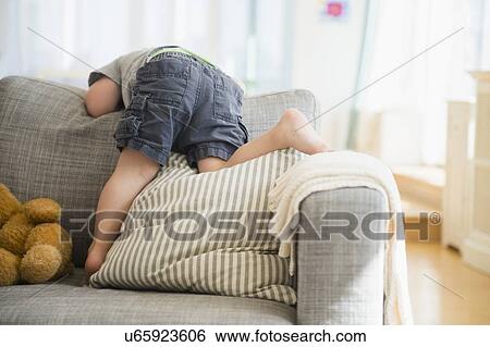 Stock Photograph - Boy (2-3) playing on sofa. Fotosearch