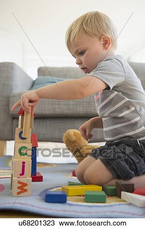 Stock Image - Boy (2-3) playing with blocks in living room. Fotosearch
