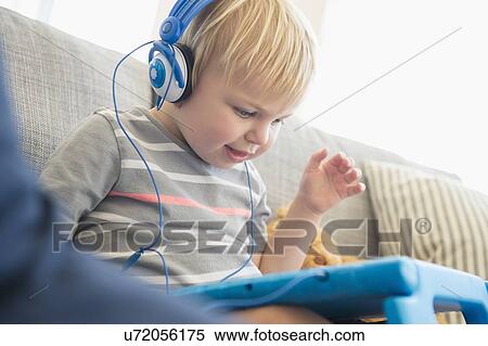 Boy (2-3) watching movies on his tablet View Large Photo Image Stock Photography - Boy (2-3) watching movies on his tablet. Fotosearch
