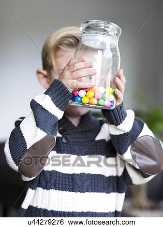 Boy (6-7) holding glass jar with candies View Large Photo Image Stock Photograph - Boy (6-7) holding glass jar with candies. Fotosearch