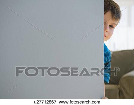 Boy (6-7) peering around door View Large Photo Image Stock Photo - Boy (6-7) peering around door. Fotosearch