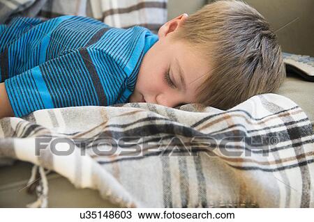 Boy (6-7) sleeping on sofa View Large Photo Image Stock Image - Boy (6-7) sleeping on sofa. Fotosearch