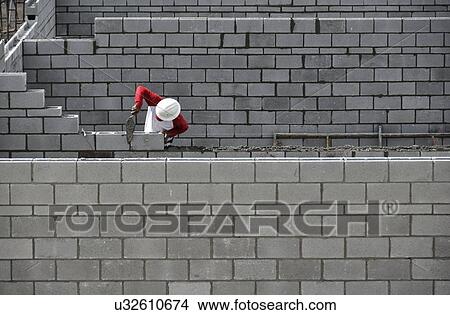 Picture - Bricklayer working on brick wall. Fotosearch