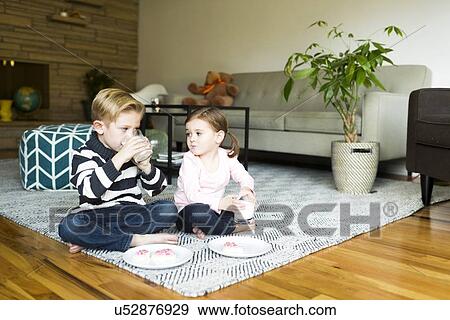 Brother (6-7) and sister (4-5) drinking milk on living room floor View Large Photo Image Stock Photo - Brother (6-7) and sister (4-5) drinking milk on living room floor. Fotosearch