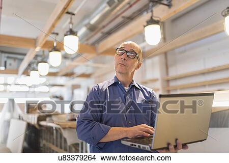 Picture - Business owner working with laptop. Fotosearch