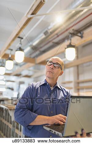 Stock Image - Business owner working with laptop. Fotosearch
