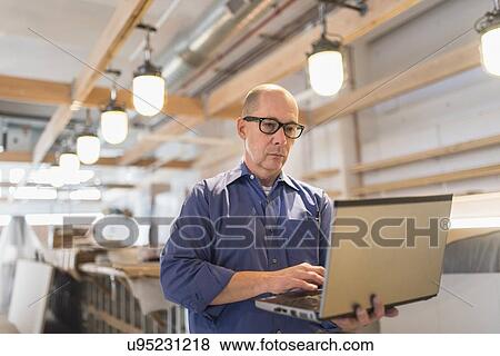Stock Photo - Business owner working with laptop. Fotosearch