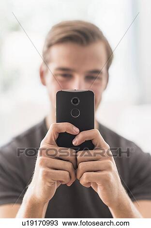 Stock Image - Close-up of man using mobile phone. Fotosearch