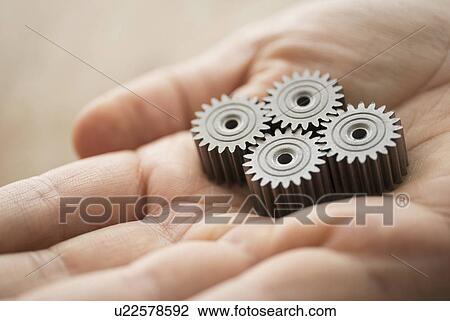 Close up of man's hand holding metal cogs View Large Photo Image Stock Image - Close up of man's hand holding metal cogs. Fotosearch