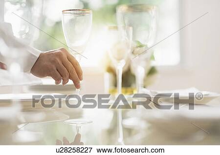 Stock Photo - Close up of man's hand setting place in restaurant. Fotosearch