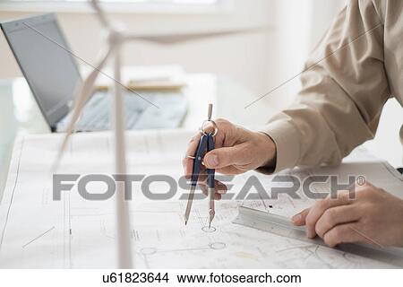 Close up of man's hands using compass while drawing plans View Large Photo Image Picture - Close up of man's hands using compass while drawing plans. Fotosearch