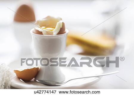 Stock Photo - Close up of soft boiled egg in egg cup. Fotosearch