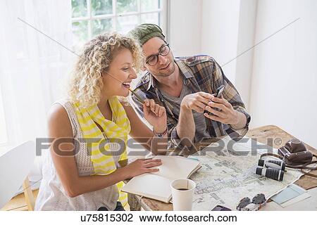 Stock Image - Couple making plans for travel. Fotosearch