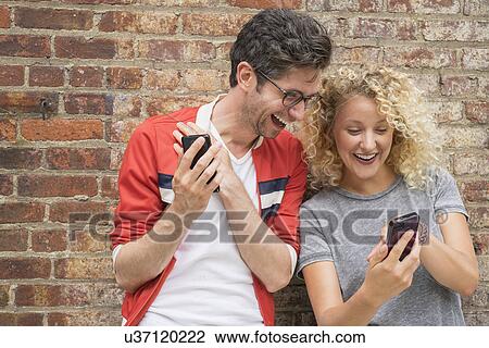 Couple sharing messages on cell phones View Large Photo Image Stock Image - Couple sharing messages on cell phones. Fotosearch