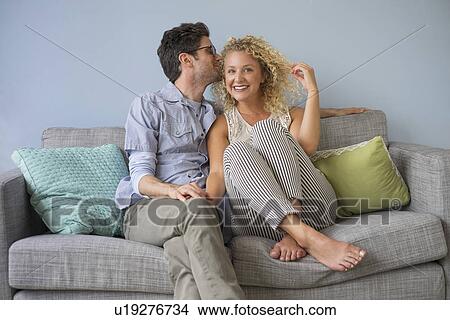 Couple sitting on sofa View Large Photo Image Picture - Couple sitting on sofa. Fotosearch
