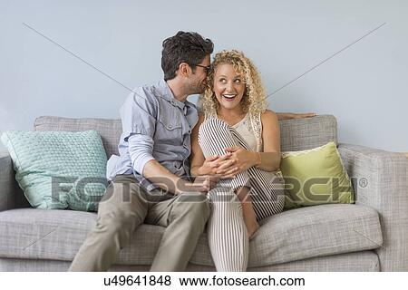 Couple sitting on sofa View Large Photo Image Stock Photo - Couple sitting on sofa. Fotosearch
