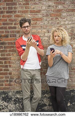Couple using cell phones View Large Photo Image Stock Image - Couple using cell phones. Fotosearch