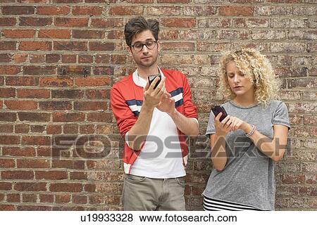 Couple using cell phones View Large Photo Image Stock Photo - Couple using cell phones. Fotosearch