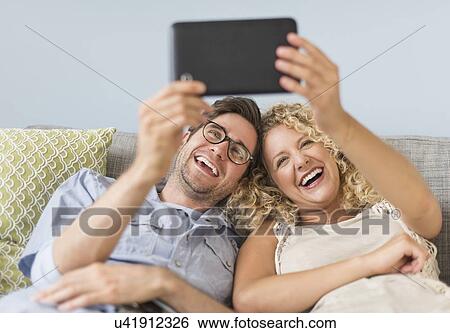 Stock Photograph - Couple using tablet pc. Fotosearch