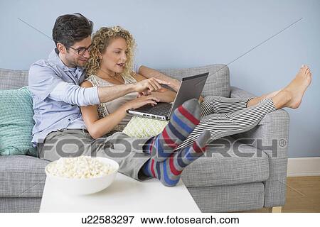 Stock Photo - Couple watching movies on laptop. Fotosearch
