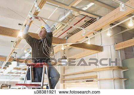 Electrician fixing lightning equipment View Large Photo Image Stock Image - Electrician fixing lightning equipment. Fotosearch