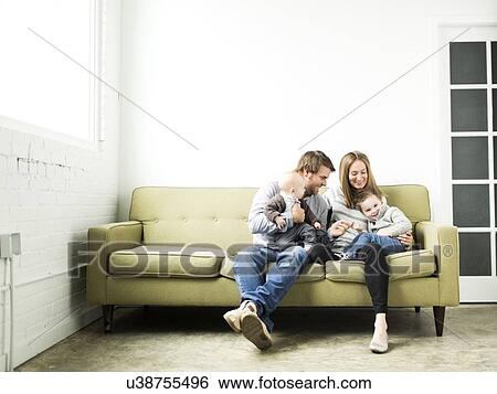 Stock Photograph - Family embracing on sofa. Fotosearch