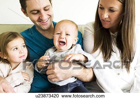 "Family with two children (2-3, 4-5) sitting on sofa" View Large Photo Image Stock Image - "Family with two children (2-3, 4-5) sitting on sofa". Fotosearch